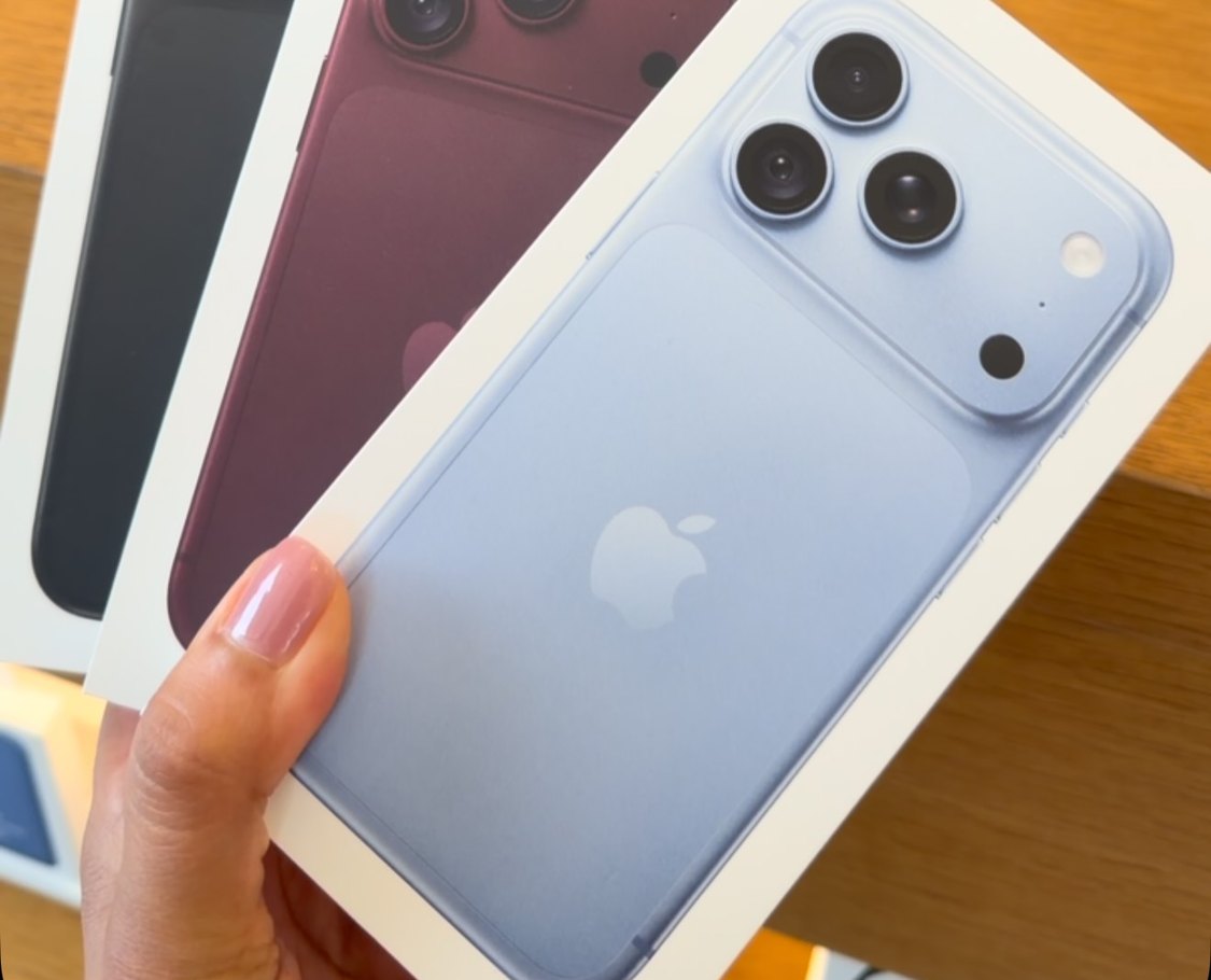 Cajas de iPhone en negro, rojo y azul sobre el mostrador